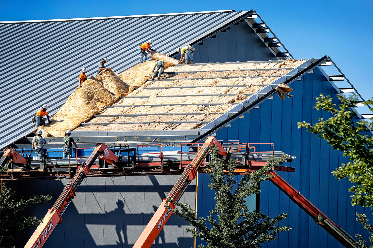 Workers install insulation in the roof at the new tennis center